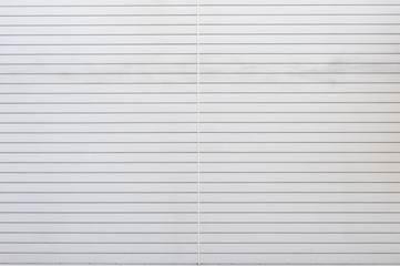 A closeup shot of automatic metal roller door used in factory, storage, garage, and industrial warehouse. The corrugated and foldable metal sheet offer space saving and provide urban and rustic feel