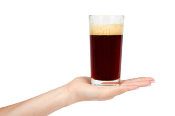 Hand with cold glass of dark beer or kvass with foam isolated on white background.