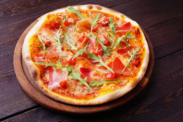 Restaurant, food delivery, pizzeria menu concept. Appetizing ham pizza with arugula. Delicious classical recipe, traditional Italian snack