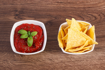 Salted potato crisps and sauce in bowls, concept of unhealthy food