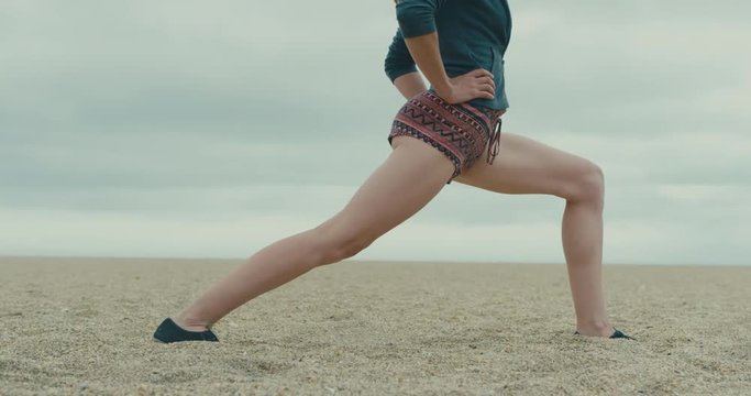 Young woman doing stretches on the beach