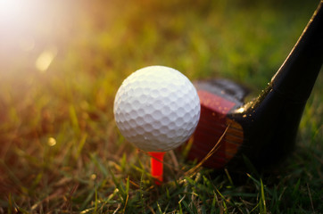 Golf clubs and golf balls are wet with warm light rain at sunset