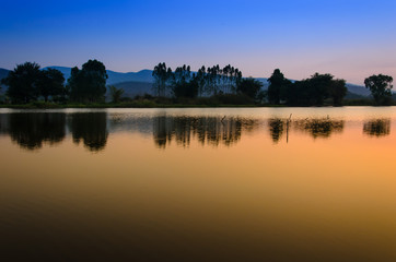 Fototapeta na wymiar Twilight sky with mountain landscape view reflects on water