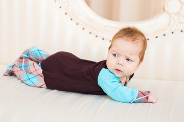 Fototapeta premium Adorable baby boy in sunny bedroom. Newborn child relaxing