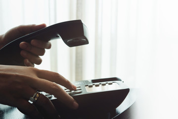 Close-up of Woman's Hand using a Telephone in House or Hotel near the Window