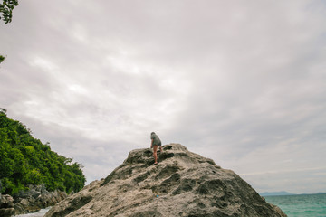 Man standing on the edge of the cliff in an deserted island.