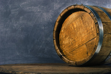 Barrel on an old round wooden table. Beautiful dark background