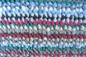 motley mohair fabric close-up fluffy background for decor natural material carpet tapestry woolen cloth scarf knitted from multi-colored thread red burgundy blue green gray stripes