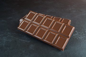 A bar of chocolate over black background