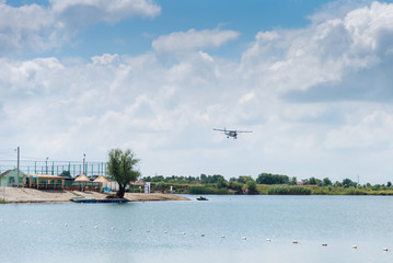 A small plane flying above the lake