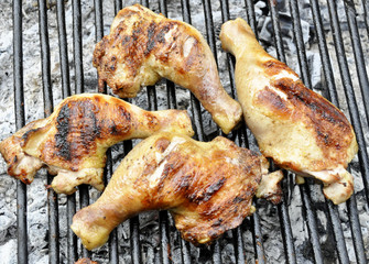 Grilled chicken thigh on the flaming grill