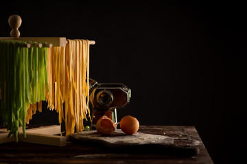 Freshly prepared Tagliatelle paste is dried on a wooden drier. Traditional italian cuisine