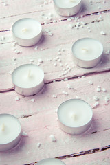 A few flat white candles on a beautiful wooden table