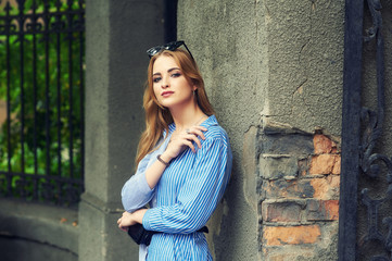 Attractive young girl on the old city street .  Beautiful fashionable woman in summer outdoors . Women's beauty and fashion concept