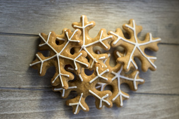 Traditional Czech tasty white painted brown gingerbreads, Christmas snowflakes on wooden table