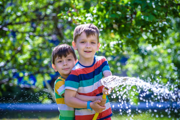 Brothers having fun splash each other with water in the village