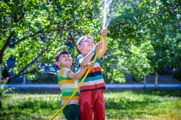 Brothers having fun splash each other with water in the village