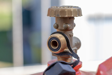 Metallventil einer Gasflasche an einem Gasgrill im Garten