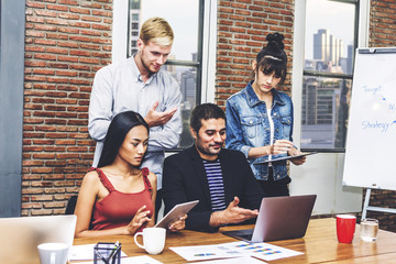 Group of casual business working and discussing strategy with desktop computer.creative business people planning and brainstorm in modern work loft.Teamwork concept