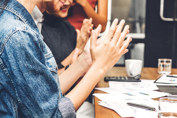Successful business people clapping hands in the meeting