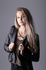 Close up studio portrait of a pretty blonde woman, smiling and looking at the camera