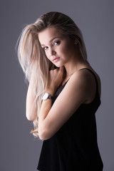 Naklejka premium Close up studio portrait of a pretty blonde woman, smiling and looking at the camera