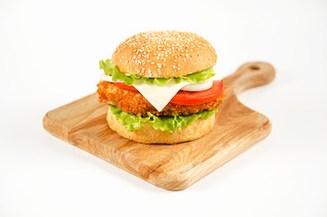 Hamburger lies on a cutting board on a white background.