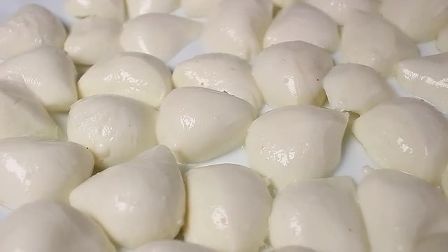 Mozzarella cheese balls rotating pattern macro texture background backdrop footage video.