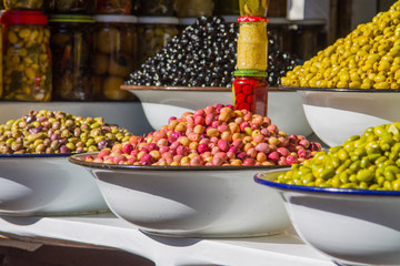Olives and various spicy pickles in a large bowl on the shelves at the market in Marrakesh. Morocco. Africa