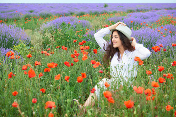 young girl is in the lavender field with red poppy flowers, beautiful summer landscape