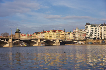 Landmark Picture of the Prague river side with bridge and buildings on the bank of Vltava river with famous dancing house, Picture is taken in sunny spring day. 
