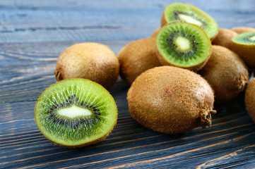 Fresh ripe kiwi fruit on a wooden table. Whole and half-cut fruits. Tropical fruit. Healthy food.