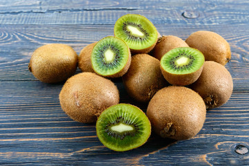 Fresh ripe kiwi fruit on a wooden table. Whole and half-cut fruits. Tropical fruit. Healthy food.
