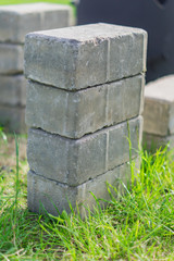 Naklejka premium pile of pavement gray bricks on green grass