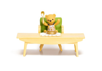 Lovely miniature toys brown teddy bears sitting on the chair behind the table with mixed fruit tart isolated on white background.Clipping path included.