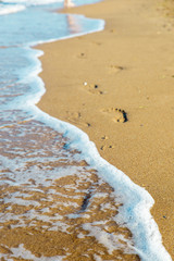 traces of a woman's legs on the sandy beach