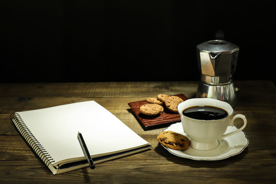 Hot coffee and note pade isolated on wooden table
