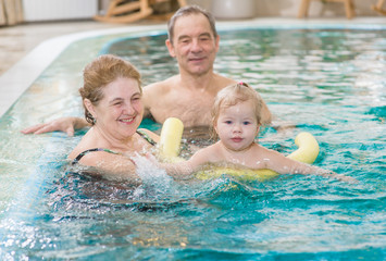 Fototapeta premium grandmother teaches granddaughter to swim in the pool