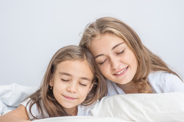 Happy mom and daughter sleeping together on the bed