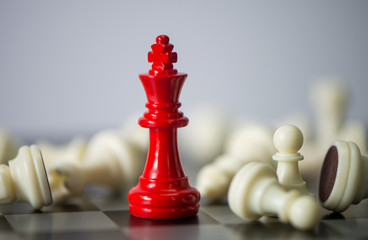 Red chess between black chess board game for competition and strategy, business success concept