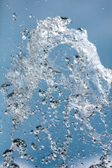 Splashing water with drops on the sky background