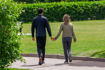 A guy with a girl is walking by the arms