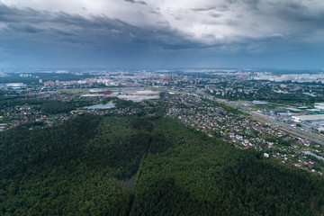 Aerial view of wheat fields, meadow, forest and village in rural Russia.