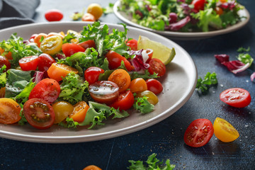 Fresh Cherry Tomato mix salad with lettuce, lemon, lime, black pepper and sea salt. healthy food