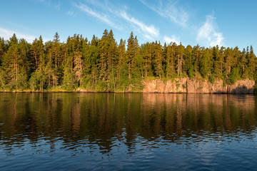 Rocky shore of the island in the morning sun. Valaam is a cozy and quiet piece of land, the rocky shores of which rise above the lush waters of lake Ladoga