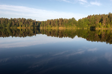 Morning dawn and mirror reflection of the coastline of the island of Valaam. Valaam is a cozy and quiet piece of land, the rocky shores of which rise above the lush waters of lake Ladoga