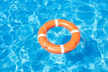Summer Still Life with an orange lifebuoy on a background of blue water pool - Powered by Adobe