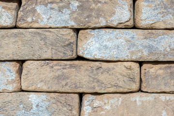 Wall of an old uneven brown brick. background. close up