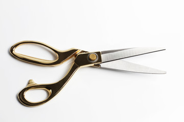 Gold scissors isolated on white background.
