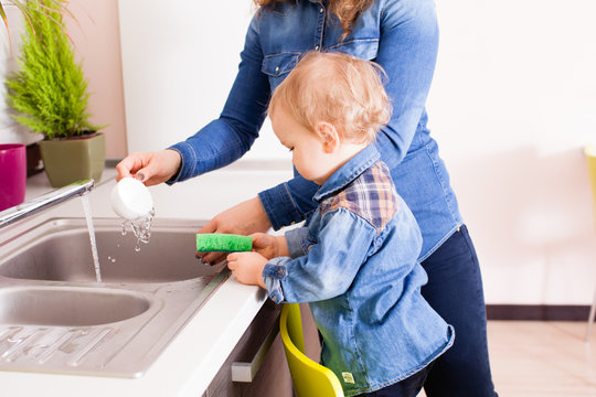 Baby boy washing dishes - Powered by Adobe